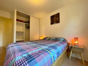 - une chambre avec un lit et une table avec une lampe dans l'établissement L'appartement Michelet - Parking, à Carcassonne