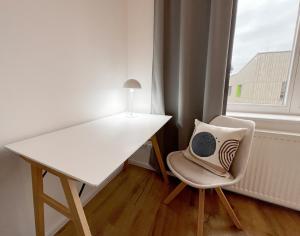 białe biurko i krzesło z poduszką w obiekcie Wohnung in Radebeul w mieście Radebeul