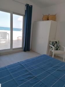 um quarto com uma cama azul e vista para o oceano em Pavlos Apartment em Kalyves
