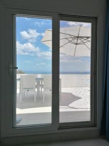 uma janela com vista para uma mesa e um guarda-chuva em Pavlos Apartment em Kalyves