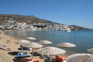 a beach with umbrellas and people on the water at Anna's Home in Batsi +10 photos
