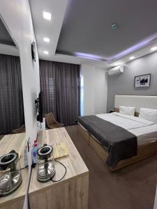 een slaapkamer met een groot bed en een tafel met een bed bij Noor hotel in Baku