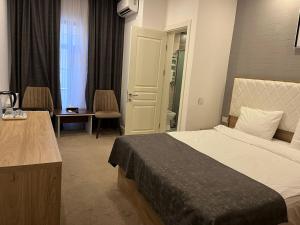 Noor hotel في باكو: غرفة فندقية بسرير وطاولة وكراسي