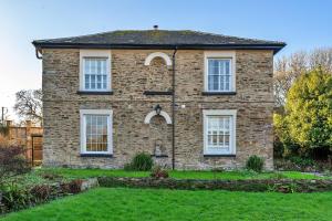 an old brick house with white windows and a yard at Finest Retreats - The Old Counting House in Gweek
