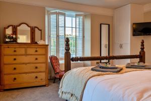 1 dormitorio con cama, tocador y espejo en Finest Retreats - The Old Counting House, en Gweek
