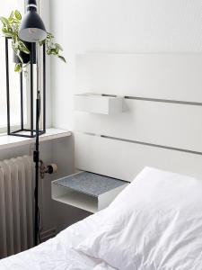 ein Schlafzimmer mit einem weißen Bett und einem Heizkörper in der Unterkunft Rosen in Nässjö