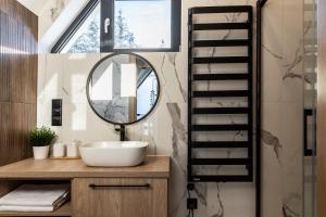 W łazience znajduje się umywalka i lustro. w obiekcie Domki przy Szlaku Pod Gubałówką w Zakopanem