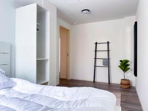 ein Schlafzimmer mit einem weißen Bett und einer Pflanze in der Unterkunft Rosen in Nässjö