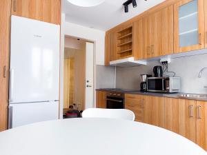 eine Küche mit einem weißen Kühlschrank und Holzschränken in der Unterkunft Rosen in Nässjö