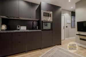 a kitchen with black cabinets and stainless steel appliances at Urban and Central Apt 5pax en Calle Silva-Gran Via in Madrid