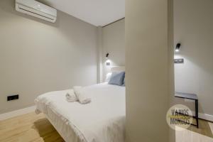 a white bedroom with a bed and a wall at Urban and Central Apt 5pax en Calle Silva-Gran Via in Madrid