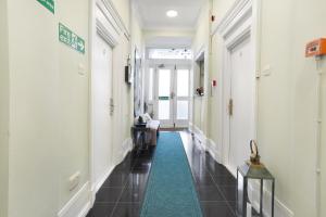 un couloir avec un tapis vert dans un bâtiment dans l'établissement BeiRoom Hyde Park Apartments, à Londres