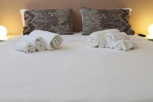 a bed with three rolled towels on it at Expo Fiera Milano San Siro in Settimo Milanese