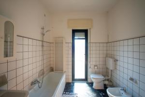 a bathroom with a tub and a toilet and a sink at Guest House Ca' Lou al Teatro in Vicenza