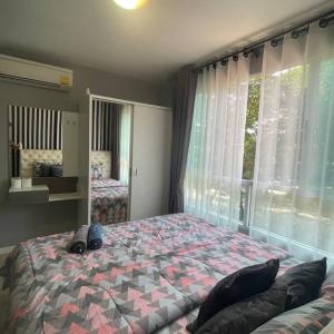 a bedroom with a large bed and a window at D condo sign D3 in Chiang Mai