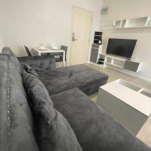 チェンマイにあるD condo sign D3のソファとテレビのあるリビングルーム