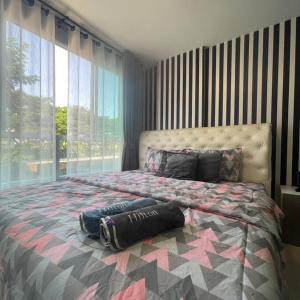 a bedroom with a large bed with a large window at D condo sign D3 in Chiang Mai