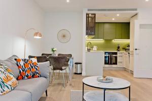 - un salon avec un canapé et une table dans l'établissement Immaculate new 1 bed AC & pool Chelsea, à Londres