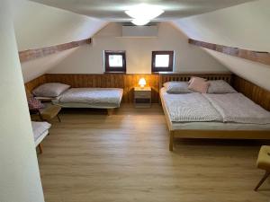 a room with two beds in a attic at Exclusive Retreat Slavinka in Janov