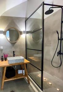 cabina de ducha con lavabo y espejo en Kynthia Suite - Escape to Seaside Makry Gialos en Makry Gialos