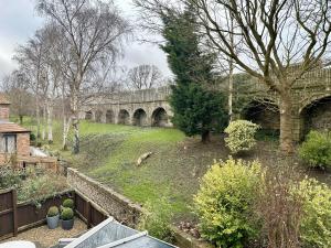 vistas a un jardín con un puente de piedra en New Tower House - At 10 pear tree court with parking, en York