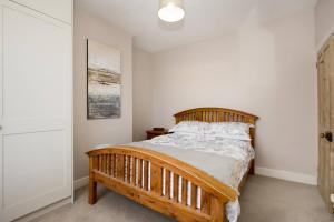 a bedroom with a wooden bed in a room at Pass the Keys Bright PetFriendly Terrace home in Stony Stratford in Stony Stratford