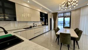 a kitchen with a table and chairs and a dining room at Villa Wolverine in Gabala