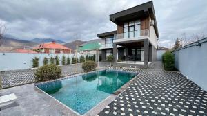 a swimming pool in front of a house at Villa Wolverine in Gabala