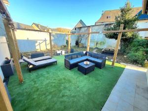 patio z kanapami i stołem na trawie w obiekcie [LE REPOS] Maison 6 couchages avec jardin privé w mieście Loubajac
