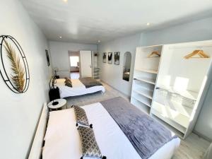 1 dormitorio con 2 camas y 1 habitación con estanterías en [LE REPOS] Maison 6 couchages avec jardin privé, en Loubajac