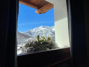 una finestra con vista sulle montagne di La Maison - Il Riparo del Cervo a Bardonecchia
