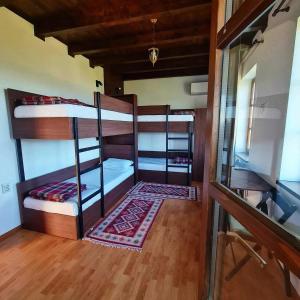 a room with three bunk beds and a desk at Eco Lodge St Ignatius Еко лодж Игнажден in Debelets