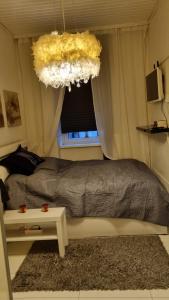 Schlafzimmer mit einem Bett, einem Fenster und einem Kronleuchter in der Unterkunft Apartment Geibel T4 - 85m2 - Highspeed Internet - Hundefreundlich in Wien