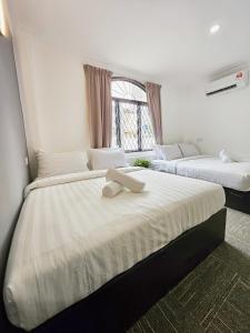 een slaapkamer met 2 bedden en een raam bij Luna Hotel by Moonknight in George Town