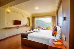 een hotelkamer met een groot bed en een raam bij Q SAINA Mapham in Darjeeling