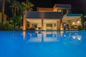 una piscina di fronte a una casa di notte di Residence Corallo Portorosa Furnari a Furnari