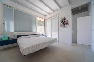 a bedroom with a bed and a large window at Residence Corallo Portorosa Furnari in Furnari