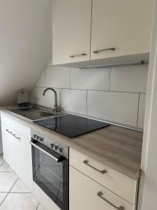a white kitchen with a sink and a stove at Aminas Ferienwohnung Bad Gandersheim 30/2 in Bad Gandersheim