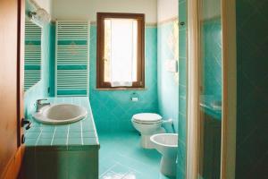 a blue bathroom with a toilet and a sink at B&B Le Tamerici in San Giorgio di Pesaro +61 photos