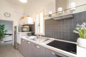 eine Küche mit einer Spüle und einem Kühlschrank in der Unterkunft Piombino Apartments - Casa Milano in Piombino