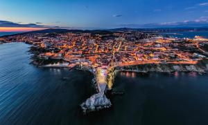 an aerial view of a city by the water at night at Piombino Apartments - Casa Mirò in Piombino