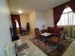 فندق روتانة الحمراء في جدة: غرفة معيشة مع أريكة وطاولة