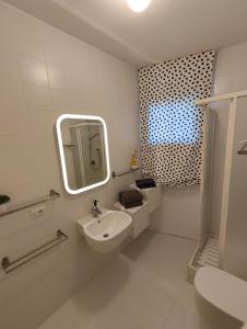 Baño blanco con lavabo y espejo en Confortevole bilocale Empoli, en Empoli