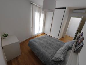 1 dormitorio con 1 cama con manta gris en Confortevole bilocale Empoli, en Empoli