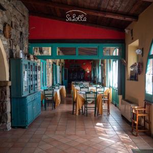 ein Restaurant mit Tischen und Stühlen in einem Gebäude in der Unterkunft Hotel Sa Lolla in Barùmini