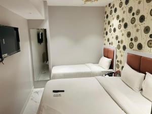 a hotel room with two beds and a tv at Grand Dyad Hotel - Near Kokilaben Hospital Andheri West in Mumbai +43 photos