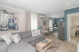 a living room with a couch and a table at Modern 1 bedroom non-seafacing unit on luxury golf estate in Knysna