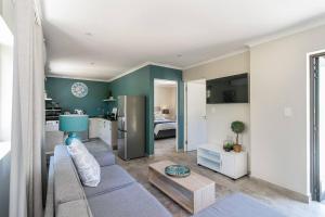 a living room with a couch and a kitchen at Modern 1 bedroom non-seafacing unit on luxury golf estate in Knysna