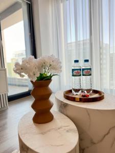 Dos botellas de agua y un jarrón con flores sobre una mesa. en Green Velvet Studio, en Brasov 42 fotos más