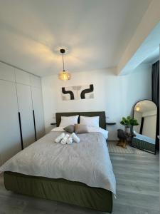 Un dormitorio con una cama con dos animales de peluche encima. en Green Velvet Studio, en Brasov